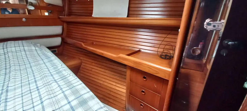 Roxanne Yacht Photos Pics Cozy cabin interior of 1990 Beneteau Oceanis Clipper 500 with wooden paneling and bed.