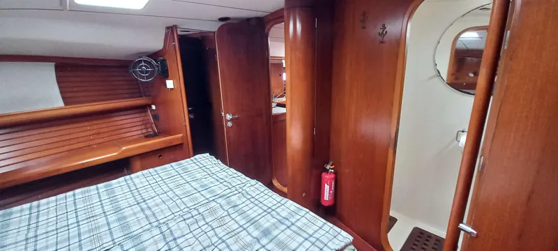 Roxanne Yacht Photos Pics Interior of 1990 Beneteau Oceanis Clipper 500 yacht cabin with wooden finish and bed.