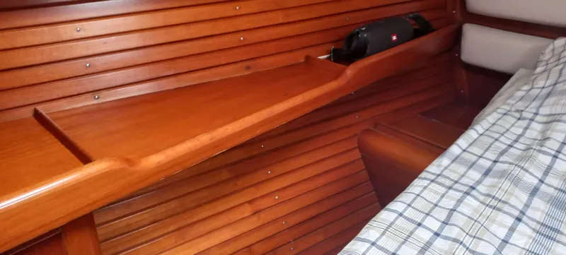 Roxanne Yacht Photos Pics Interior of 1990 Beneteau Oceanis Clipper 500 with wooden paneling and plaid bedding.