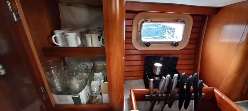 Roxanne Yacht Photos Pics Interior of 1990 Beneteau Oceanis Clipper 500 with wooden cabinets and kitchenware.