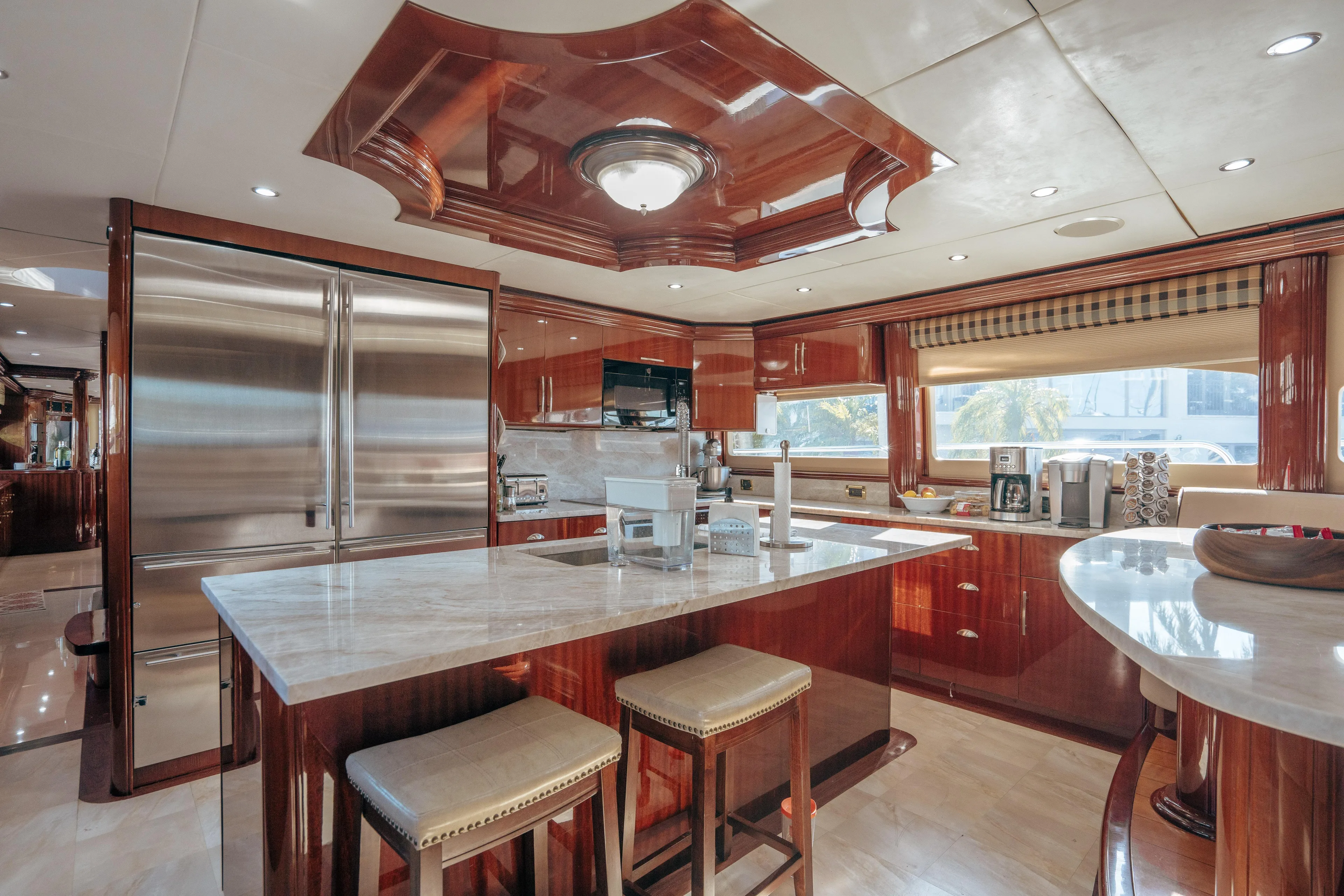Lady Kristina Yacht Photos Pics Luxurious kitchen interior of 2004 Lazzara LY106 yacht with marble countertops and wooden cabinetry.
