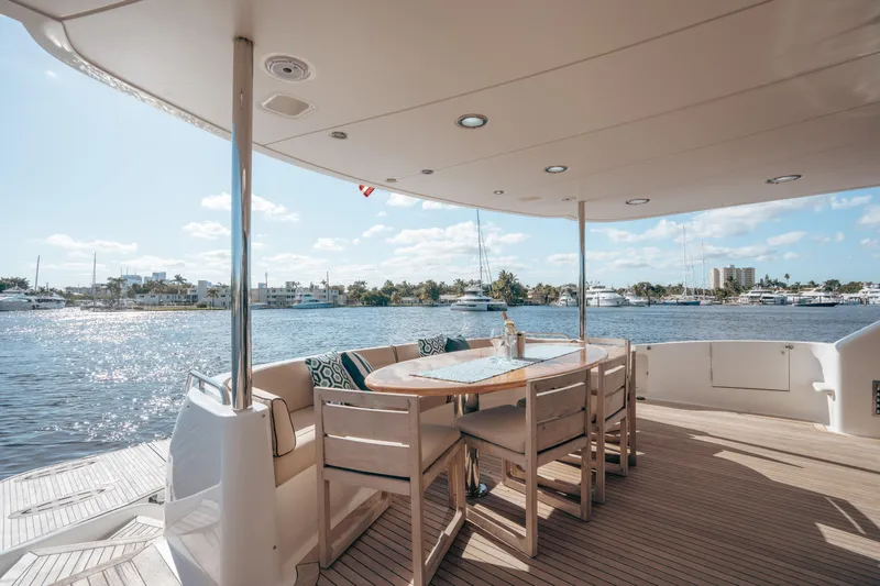 Lady Kristina Yacht Photos Pics Luxurious 2004 Lazzara LY106 yacht deck with dining area overlooking serene waterfront.