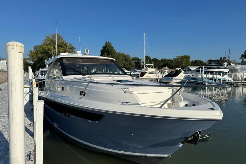  Yacht Photos Pics 2024 Pursuit OS 445 Offshore yacht docked in a marina under clear blue skies.