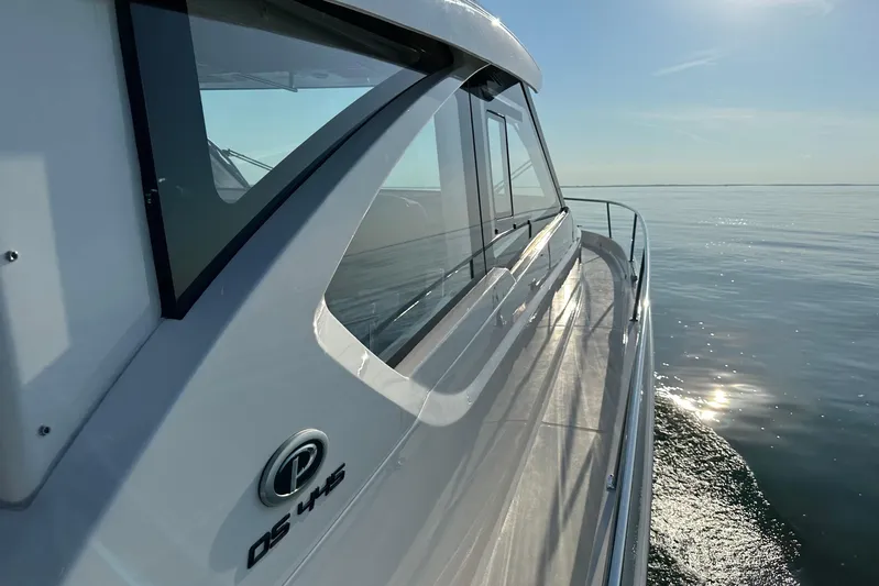  Yacht Photos Pics 2024 Pursuit OS 445 Offshore yacht cruising on calm waters under clear skies.