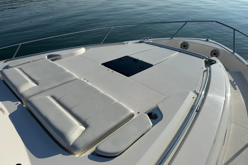  Yacht Photos Pics 2024 Pursuit OS 445 Offshore boat deck with cushioned seating, on calm water.