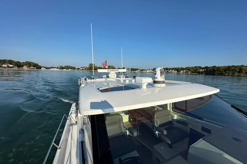  Yacht Photos Pics 2024 Pursuit OS 445 Offshore cruising on calm waters under clear blue sky.