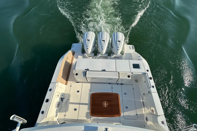  Yacht Photos Pics 2024 Pursuit OS 445 Offshore boat with triple engines on open water.