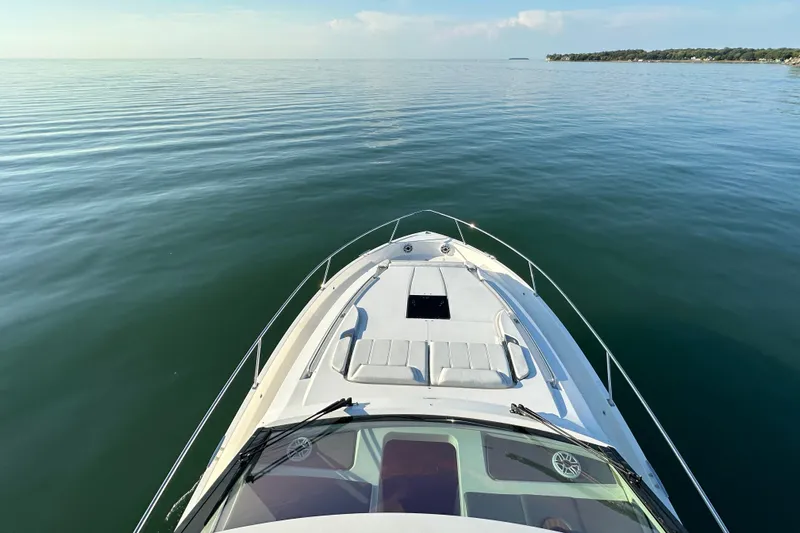  Yacht Photos Pics 2024 Pursuit OS 445 Offshore boat cruising on calm waters, scenic view.