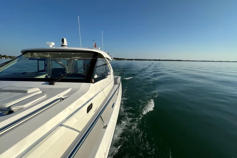  Yacht Photos Pics 2024 Pursuit OS 445 Offshore cruising on calm waters under clear blue sky.
