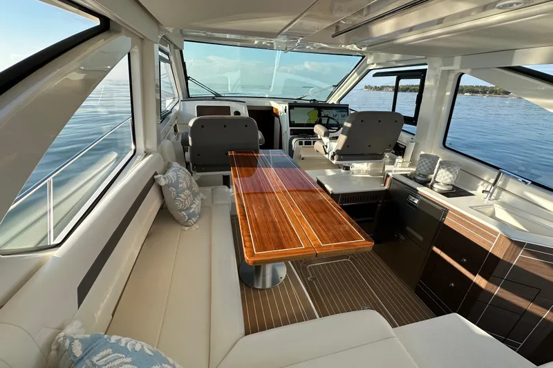  Yacht Photos Pics Luxurious interior of 2024 Pursuit OS 445 Offshore yacht with elegant seating and wooden table.