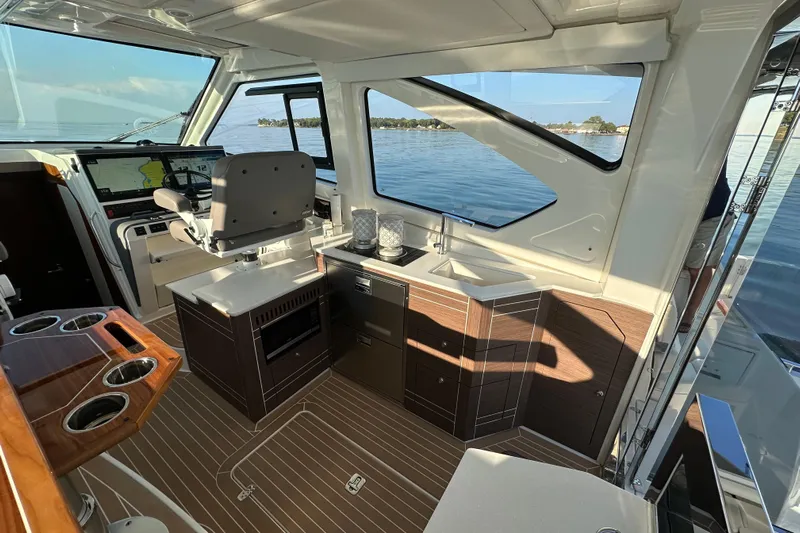  Yacht Photos Pics Luxurious interior of 2024 Pursuit OS 445 Offshore boat with modern helm and cabinetry.