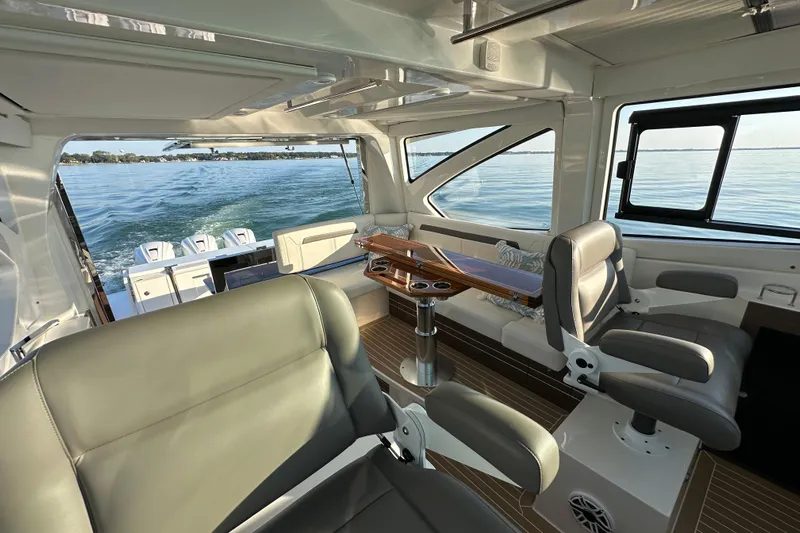  Yacht Photos Pics Luxurious interior of 2024 Pursuit OS 445 Offshore boat with leather seating and ocean view.