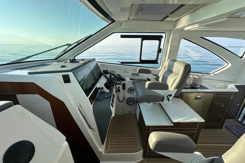 Yacht Photos Pics 2024 Pursuit OS 445 Offshore helm with modern controls and luxurious seating on calm waters.