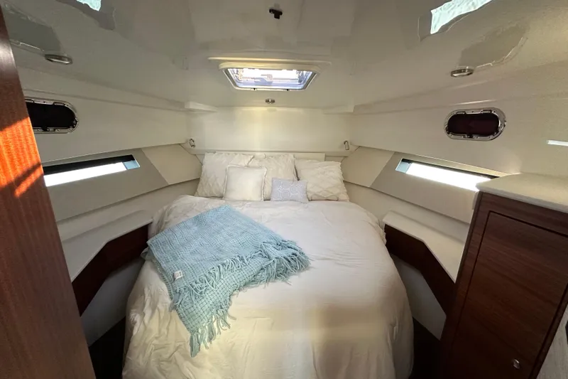  Yacht Photos Pics Luxurious cabin interior of 2024 Pursuit OS 445 Offshore yacht, featuring cozy bedding and elegant design.