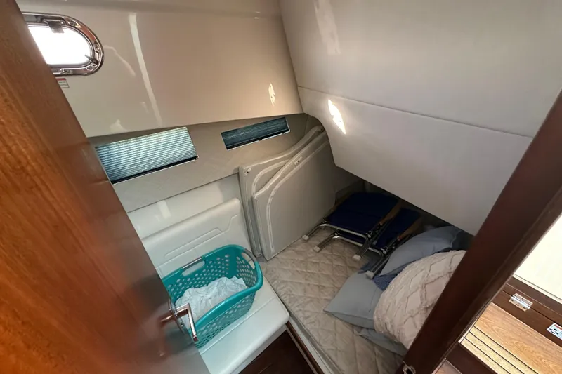  Yacht Photos Pics 2024 Pursuit OS 445 Offshore cabin interior with bedding and storage.