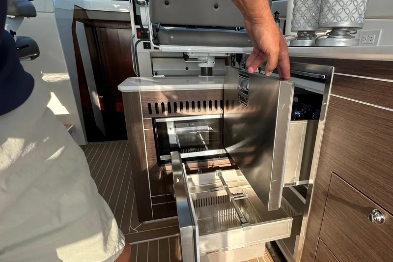  Yacht Photos Pics 2024 Pursuit OS 445 Offshore yacht interior with open stainless steel drawers and cabinetry.