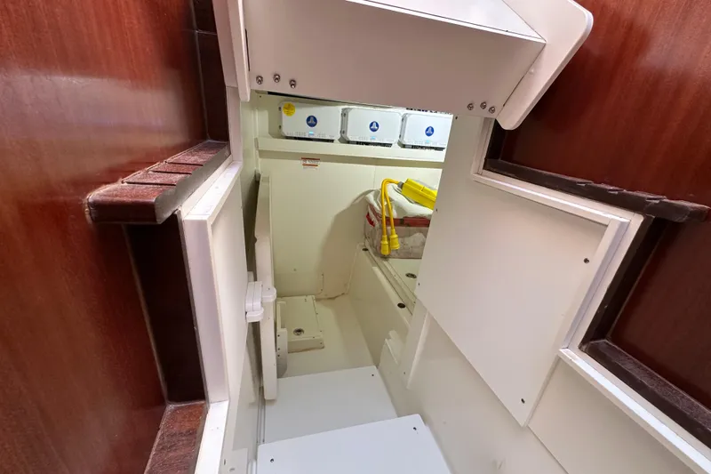  Yacht Photos Pics 2024 Pursuit OS 445 Offshore interior storage compartment with wooden accents and utility access.