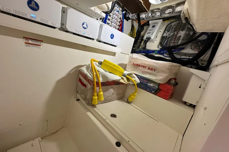  Yacht Photos Pics 2024 Pursuit OS 445 Offshore interior with life jackets and electrical equipment.