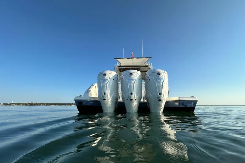  Yacht Photos Pics 2024 Pursuit OS 445 Offshore boat with triple outboard engines on calm water.