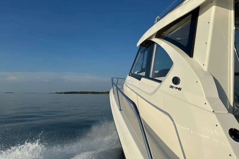  Yacht Photos Pics 2024 Pursuit OS 445 Offshore cruising on calm waters under clear blue sky.