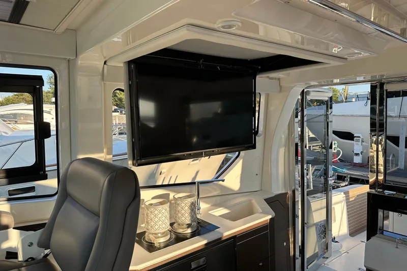  Yacht Photos Pics Luxurious interior of 2024 Pursuit OS 445 Offshore yacht with TV and seating area.