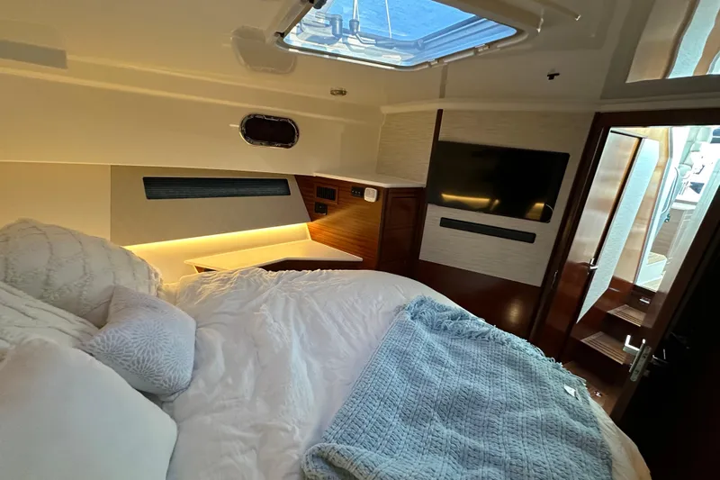  Yacht Photos Pics Luxurious 2024 Pursuit OS 445 Offshore cabin with cozy bedding and modern amenities.
