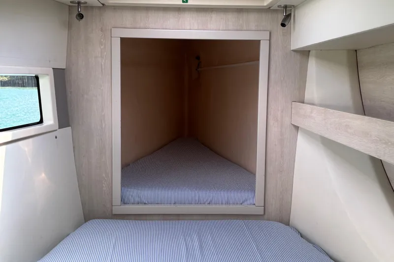  Yacht Photos Pics Interior cabin of 2016 Leopard 40 catamaran with striped bedding and window view.