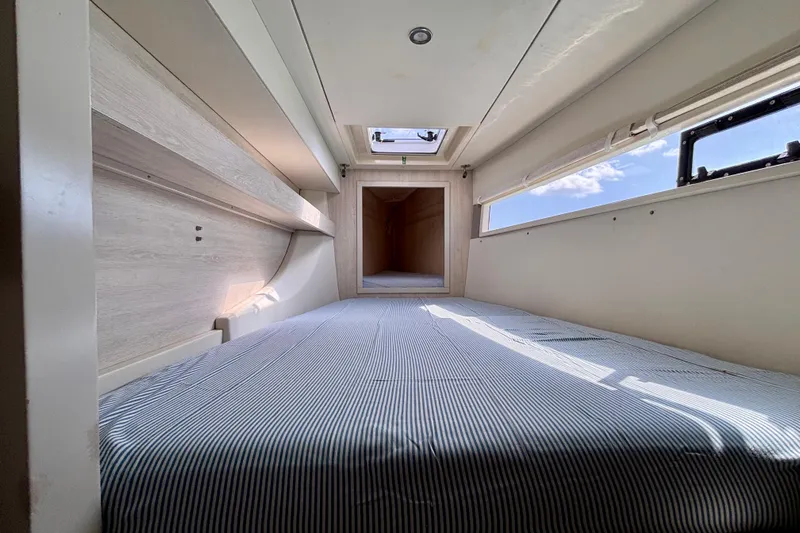  Yacht Photos Pics Interior cabin of a 2016 Leopard 40 catamaran with a striped bed and skylight.