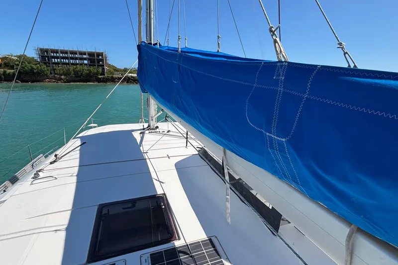  Yacht Photos Pics 2016 Leopard 40 catamaran with blue sail cover, docked near a building.