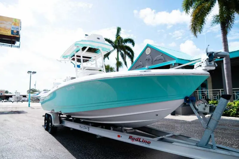 Black Label Marine Yacht Photos Pics 2024 Caymas 281 HB boat on trailer, turquoise hull, palm trees in background.