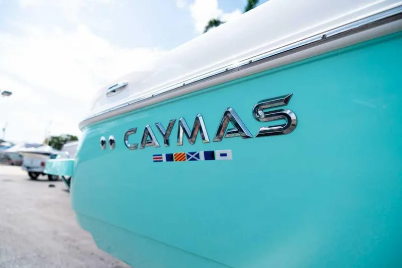Black Label Marine Yacht Photos Pics 2024 Caymas 281 HB boat, turquoise hull with chrome logo and nautical flags.