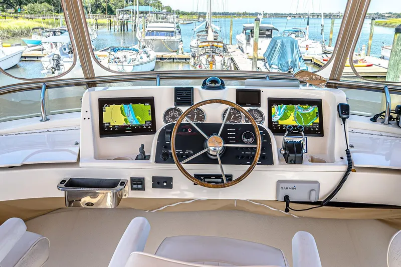 Coastal Fogg Yacht Photos Pics Helm of 2006 Mainship 34 Trawler with navigation screens and steering wheel, docked at marina.