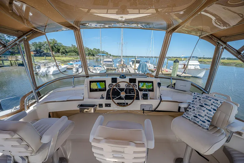 Coastal Fogg Yacht Photos Pics 2006 Mainship 34 Trawler helm with navigation screens, docked at a scenic marina.