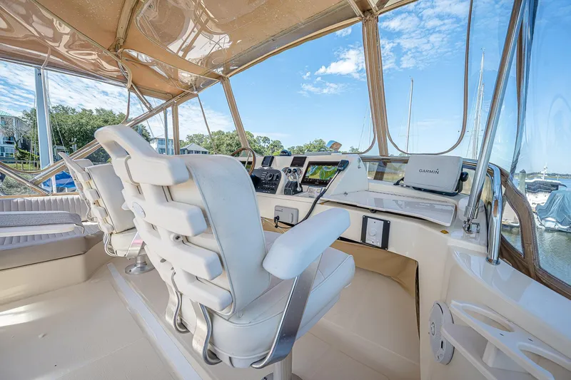 Coastal Fogg Yacht Photos Pics 2006 Mainship 34 Trawler helm with white seating and navigation equipment, docked at marina.