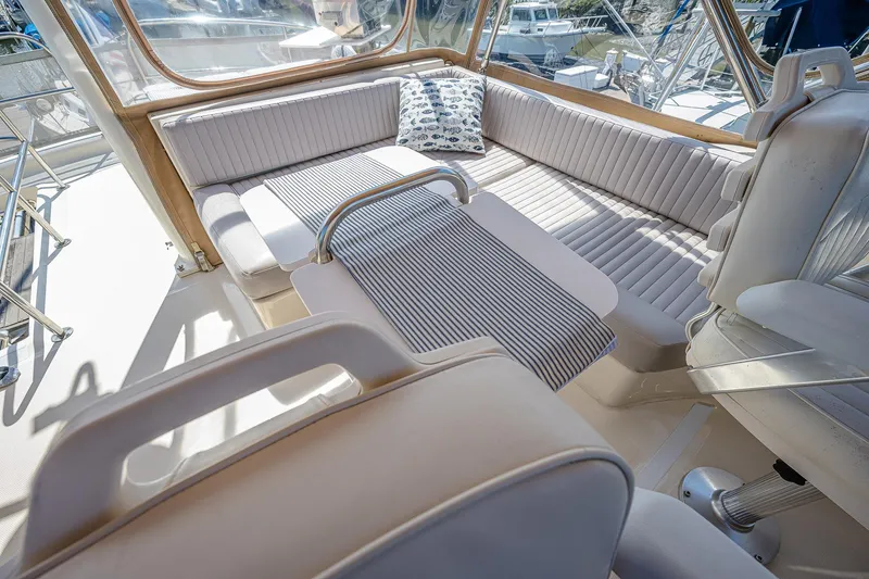 Coastal Fogg Yacht Photos Pics 2006 Mainship 34 Trawler interior with cushioned seating and striped table cover.