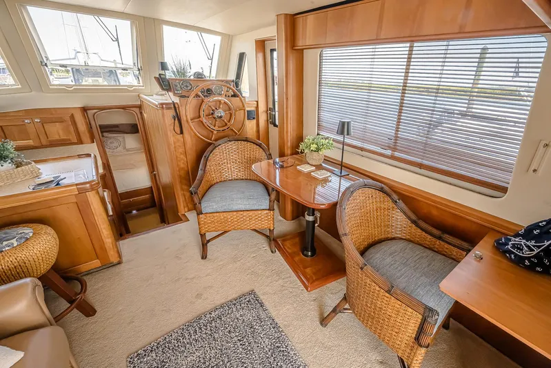Coastal Fogg Yacht Photos Pics Interior of 2006 Mainship 34 Trawler with wooden furnishings and wicker chairs.