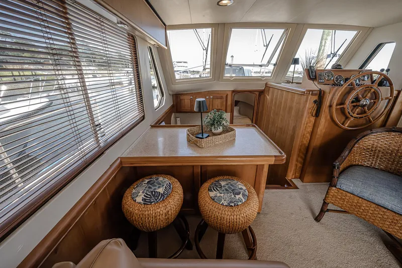Coastal Fogg Yacht Photos Pics 2006 Mainship 34 Trawler interior with wooden helm, seating, and dining area.