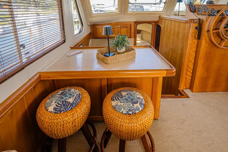 Coastal Fogg Yacht Photos Pics Interior of 2006 Mainship 34 Trawler with wooden decor and wicker stools.