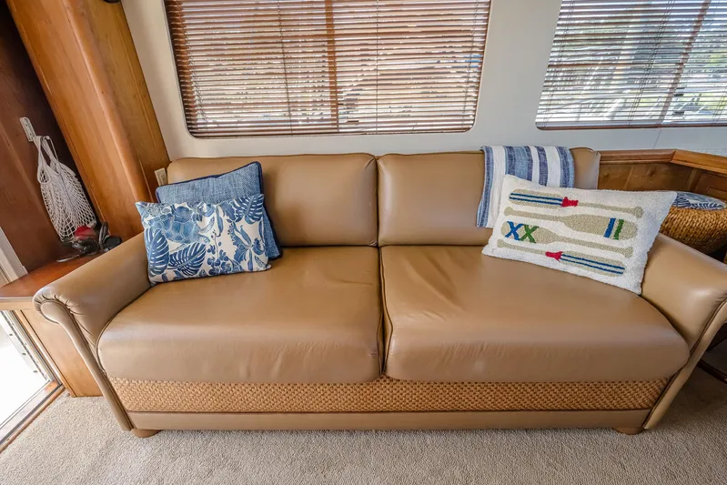 Coastal Fogg Yacht Photos Pics Beige leather sofa with decorative pillows inside 2006 Mainship 34 Trawler boat cabin.
