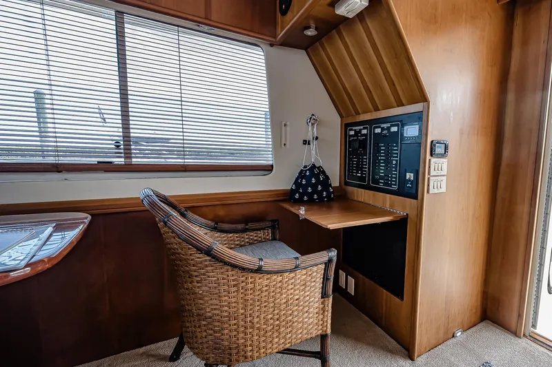Coastal Fogg Yacht Photos Pics 2006 Mainship 34 Trawler interior with wicker chair, control panel, and window blinds.