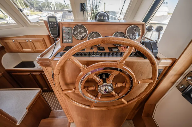 Coastal Fogg Yacht Photos Pics 2006 Mainship 34 Trawler helm with wooden steering wheel and navigation instruments.