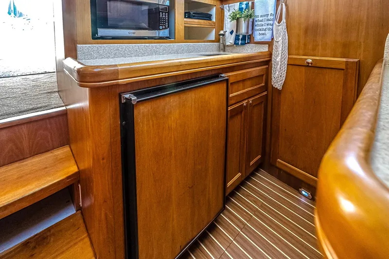 Coastal Fogg Yacht Photos Pics 2006 Mainship 34 Trawler interior kitchen with wooden cabinetry and modern appliances.