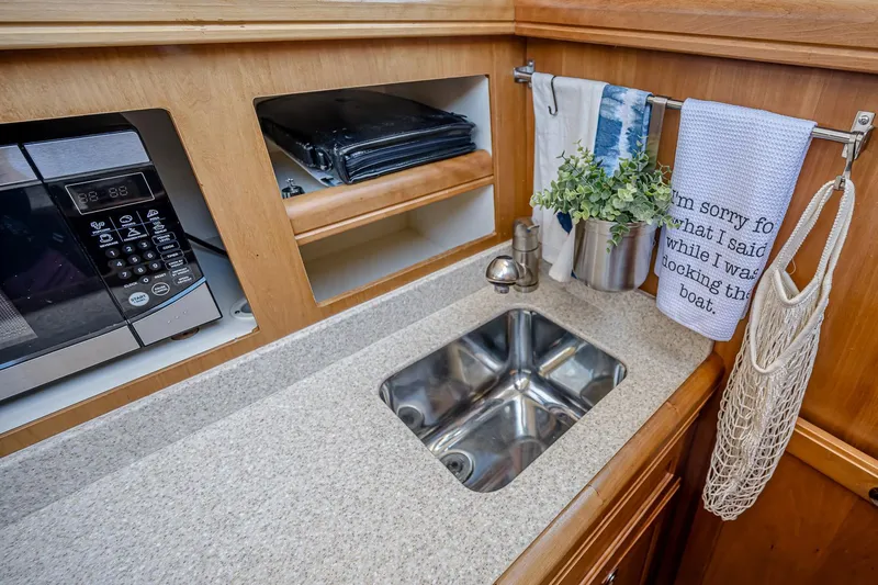 Coastal Fogg Yacht Photos Pics 2006 Mainship 34 Trawler kitchen with sink, microwave, and decorative towels.