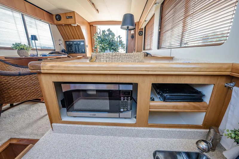 Coastal Fogg Yacht Photos Pics 2006 Mainship 34 Trawler interior with microwave, wooden cabinetry, and cozy decor.