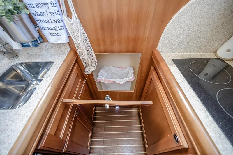 Coastal Fogg Yacht Photos Pics 2006 Mainship 34 Trawler kitchen with sink, stove, and wooden cabinetry.