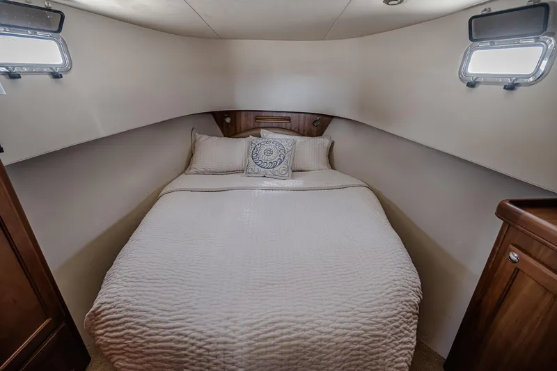 Coastal Fogg Yacht Photos Pics Cozy bedroom in 2006 Mainship 34 Trawler with elegant bedding and porthole windows.
