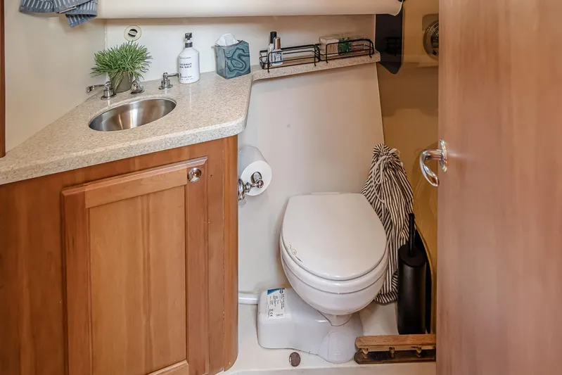 Coastal Fogg Yacht Photos Pics 2006 Mainship 34 Trawler bathroom with sink, toilet, and wooden cabinetry.