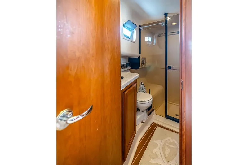 Coastal Fogg Yacht Photos Pics Bathroom interior of 2006 Mainship 34 Trawler with shower and wooden cabinetry.