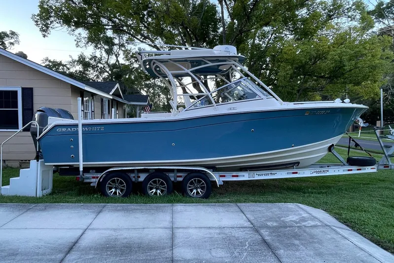  Yacht Photos Pics 2021 Grady-White Freedom 275 boat on trailer, parked beside a house.