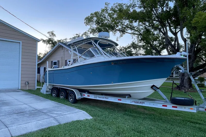  Yacht Photos Pics 2021 Grady-White Freedom 275 boat on trailer, parked beside a house.